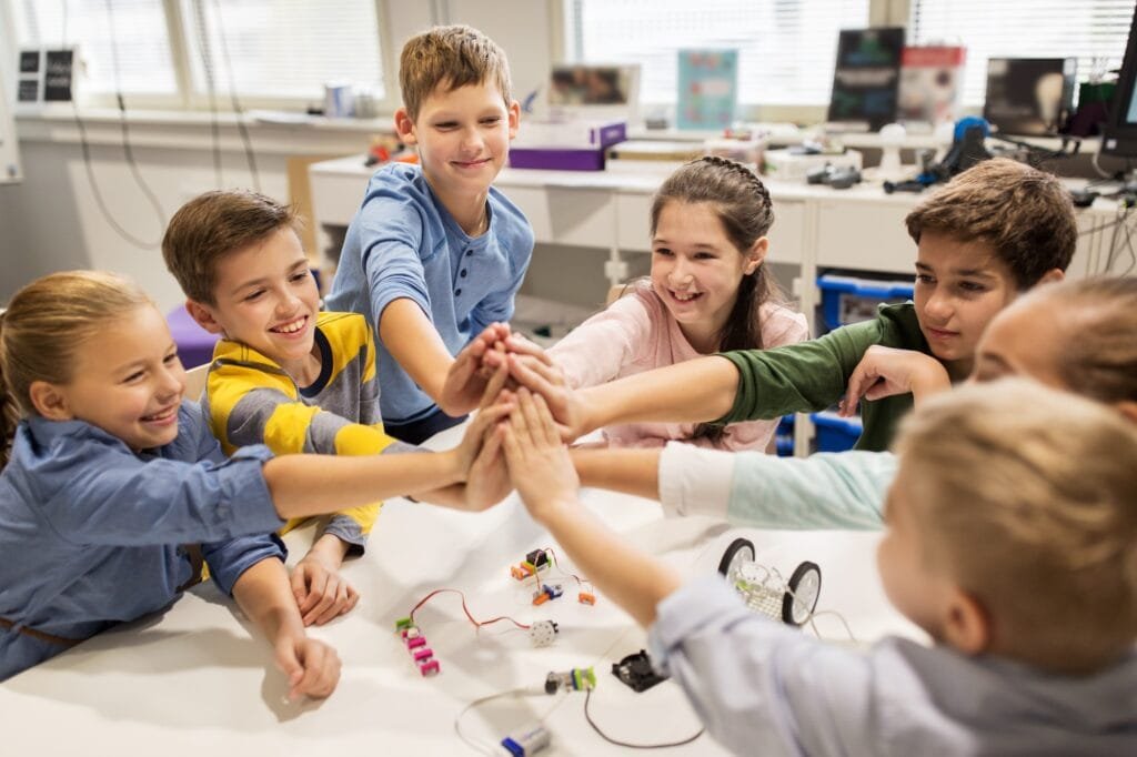 happy children making high five at robotics school