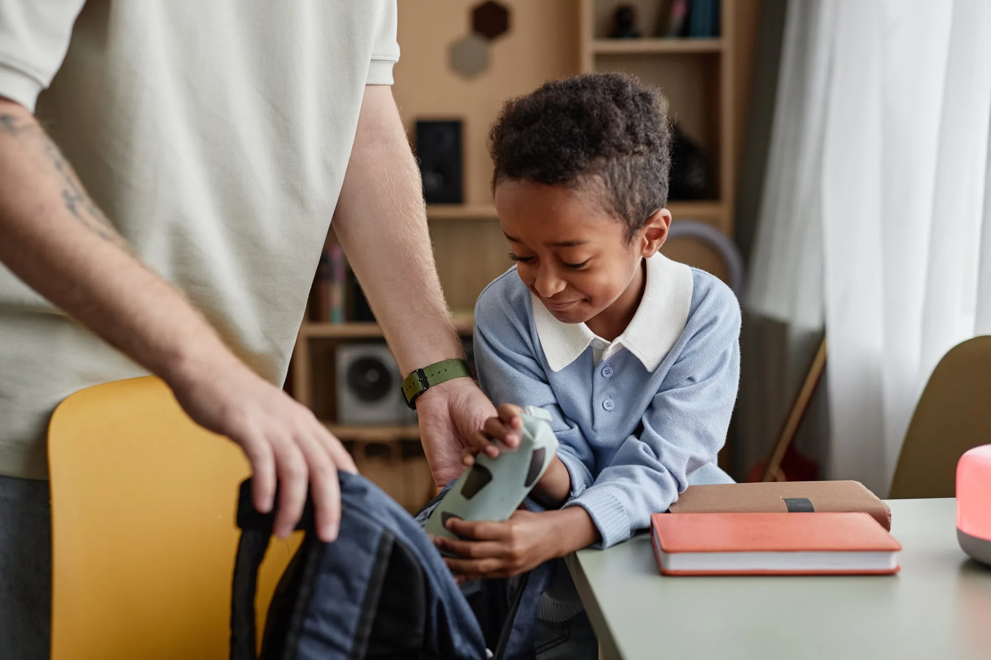 Preteen Black Boy and Dad Packing School Bag Preparing for School at Home