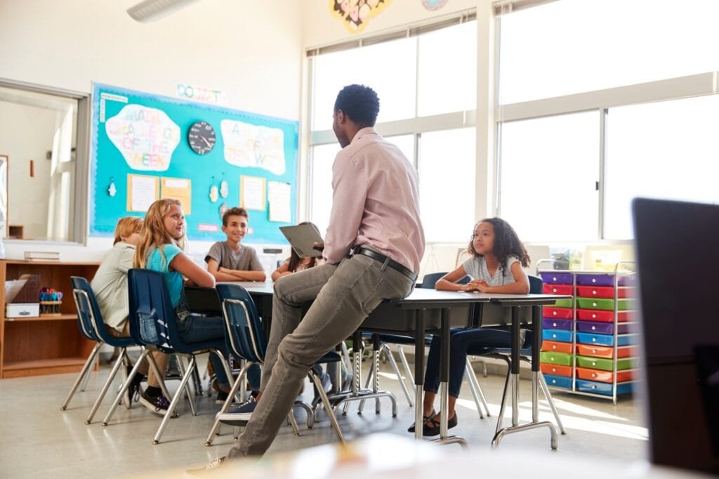 Male teacher with elementary school kids in school class